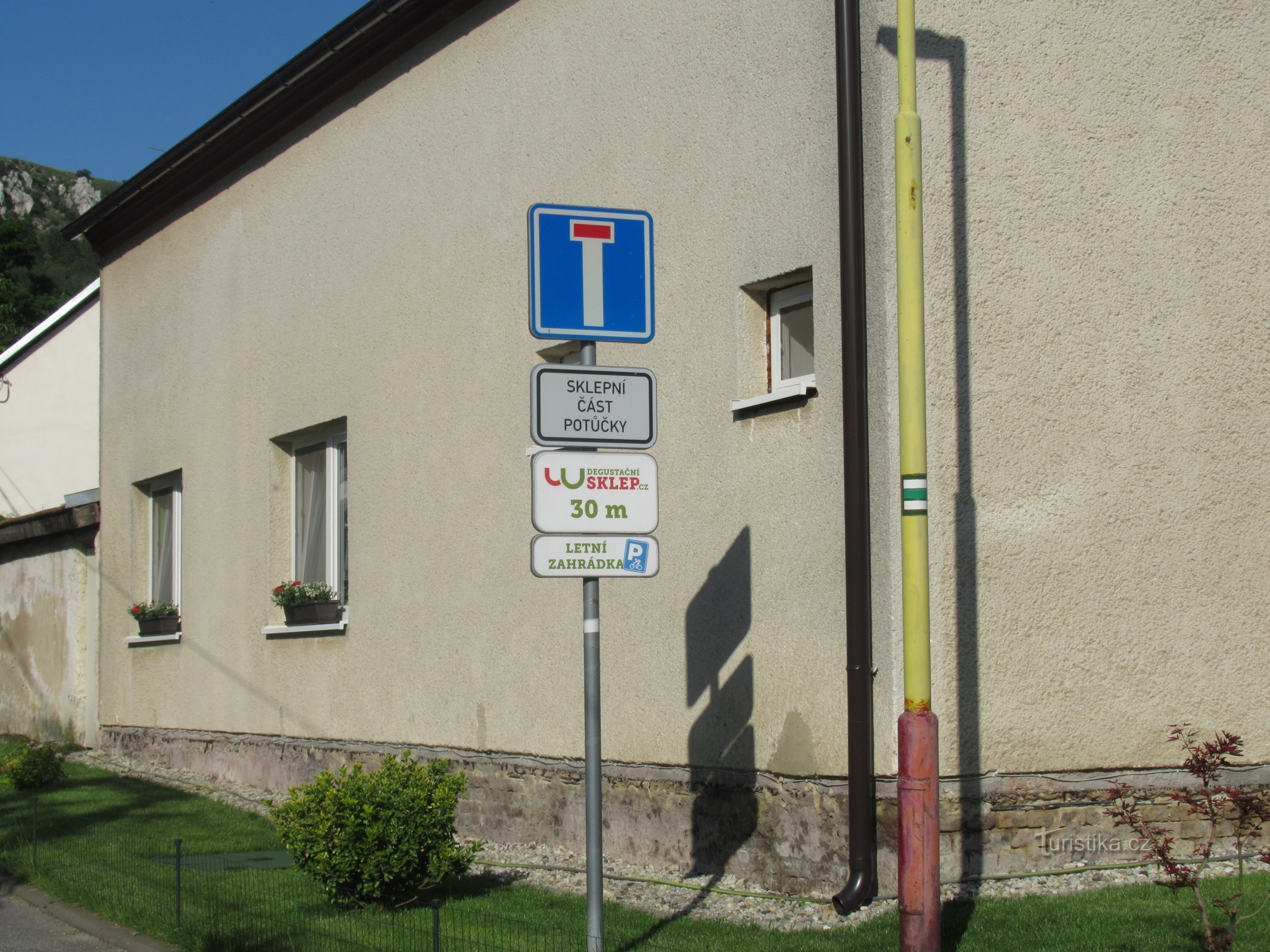 A green marked tourist path leads through the wine alley