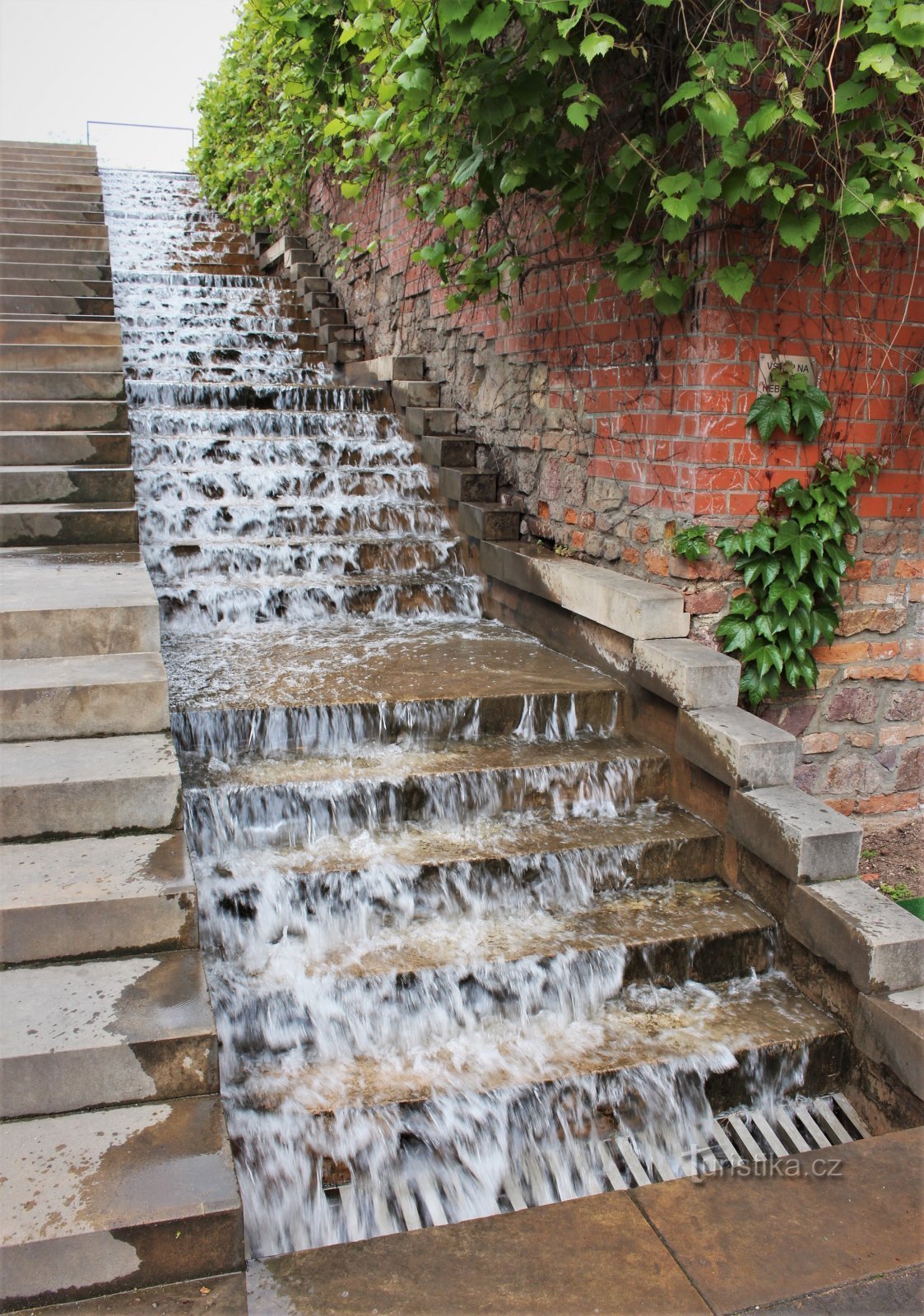 El agua cae en cascada por los escalones de hormigón junto a la escalera