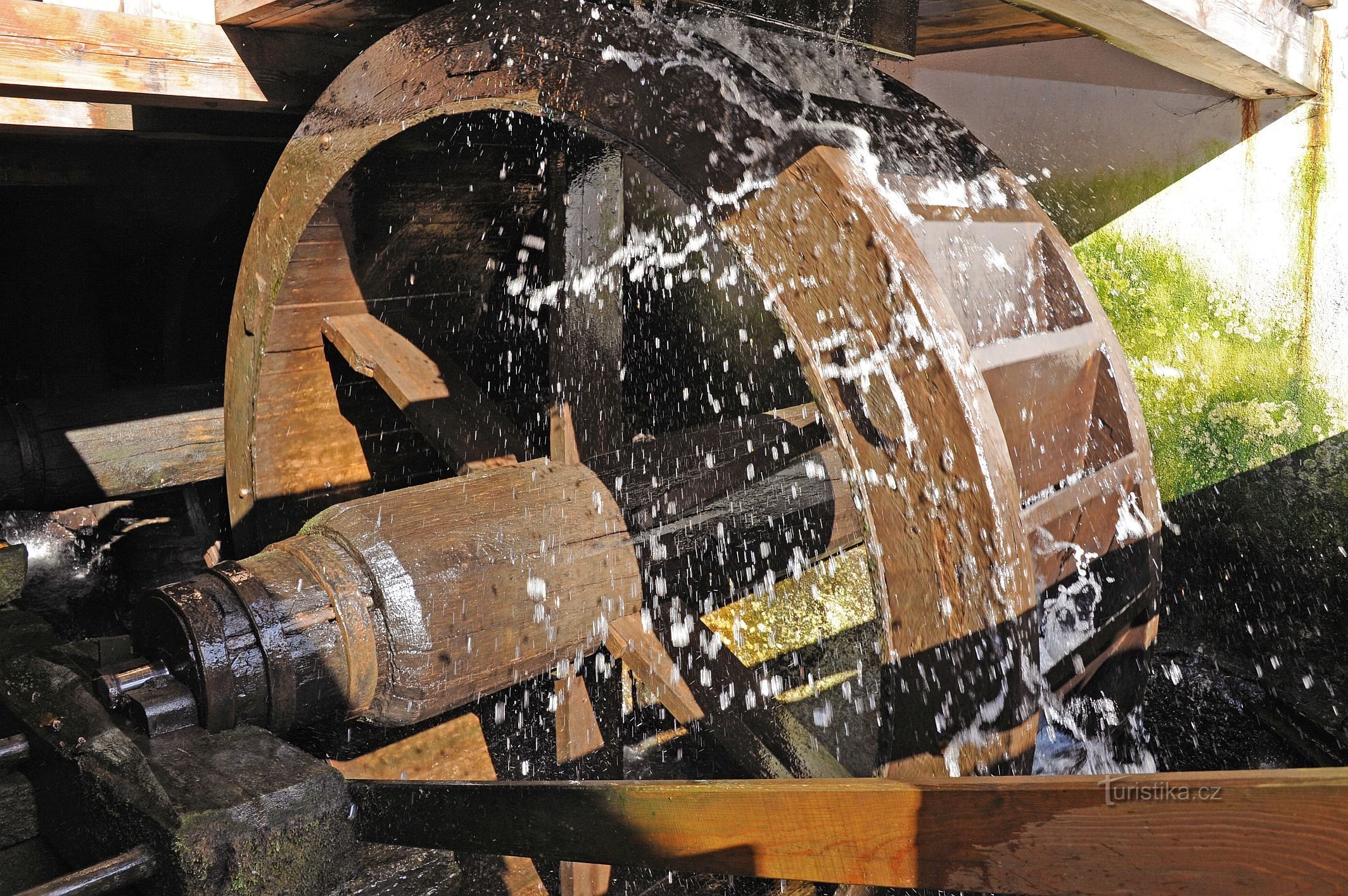 A water wheel driving a blacksmith's equipment