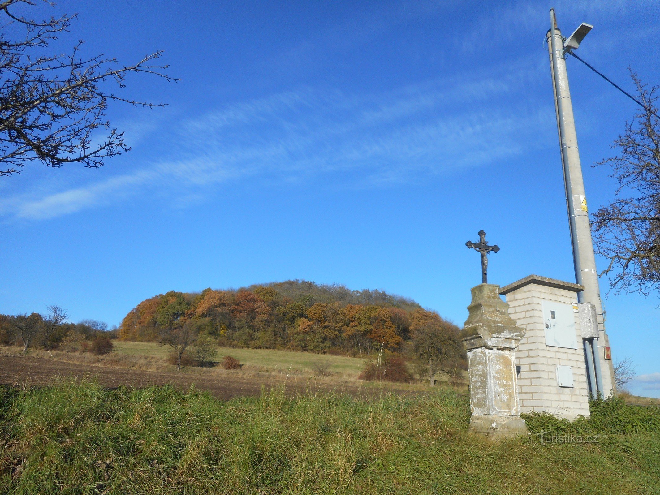 Vrch Srna en het kruis op het kruispunt in Dobkovičky.