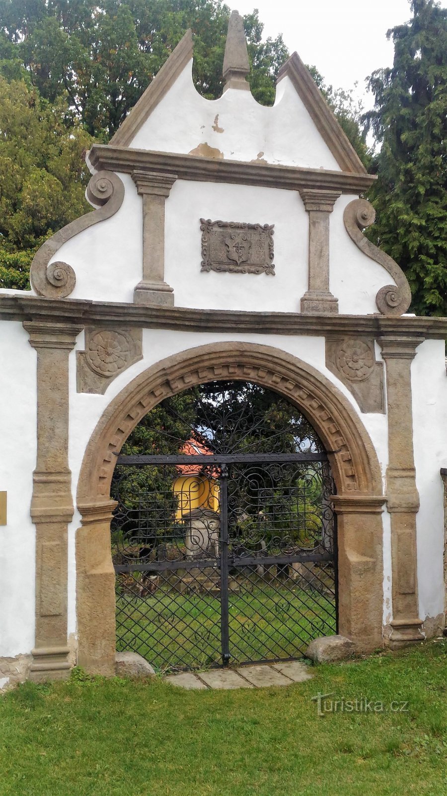 vstupní renesanční brána s tepanou mříží z roku 1615