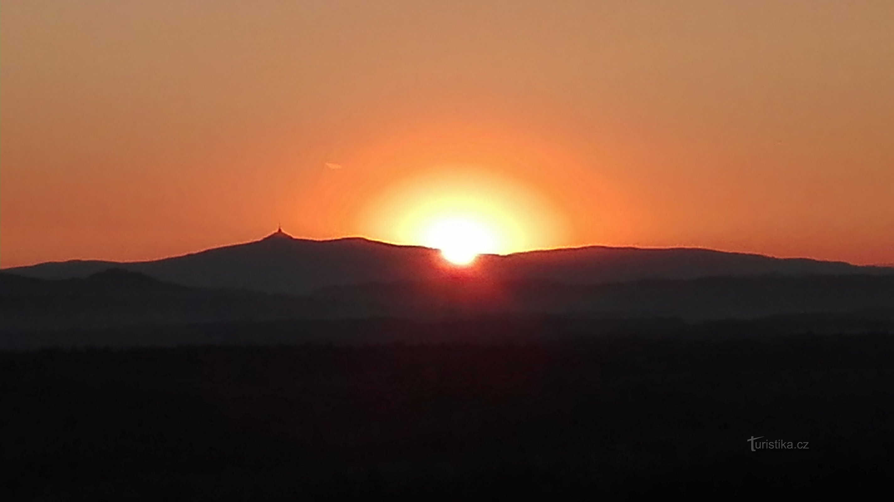 Východ slunce nad Ještědem z Hradčanské vyhlídky.