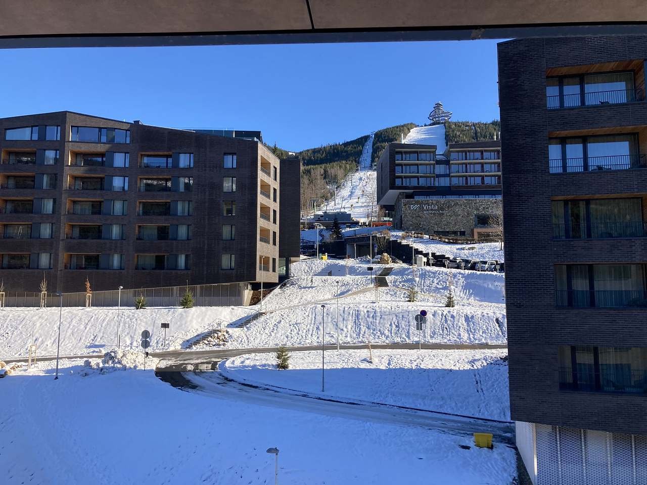 Výhled od vchodu do budovy na Stezku v oblacích a lanovku Sněžník