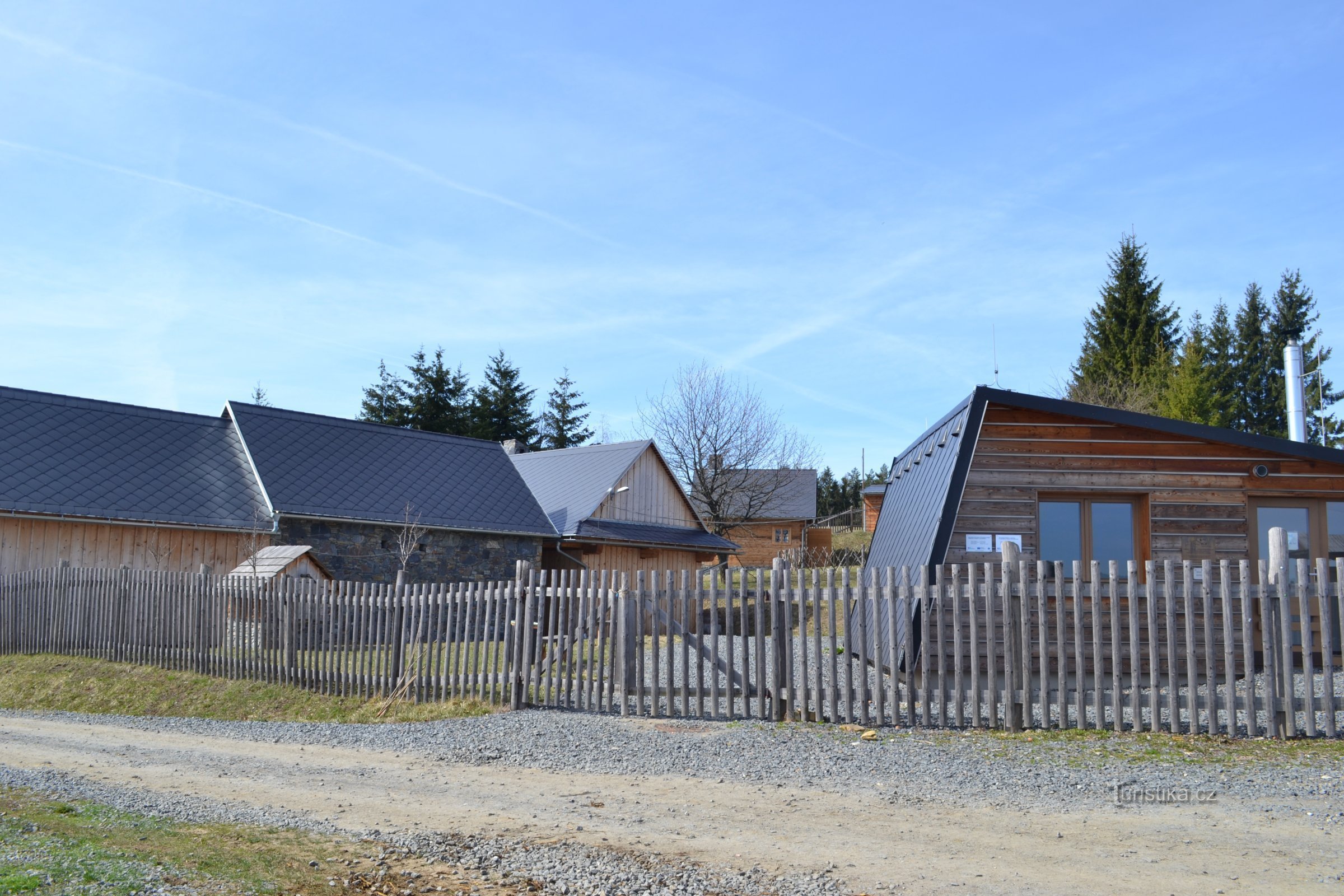 derrière la clôture, une réplique nouvellement construite des clairières de Vařák a brûlé le 2.5.1945 mai XNUMX