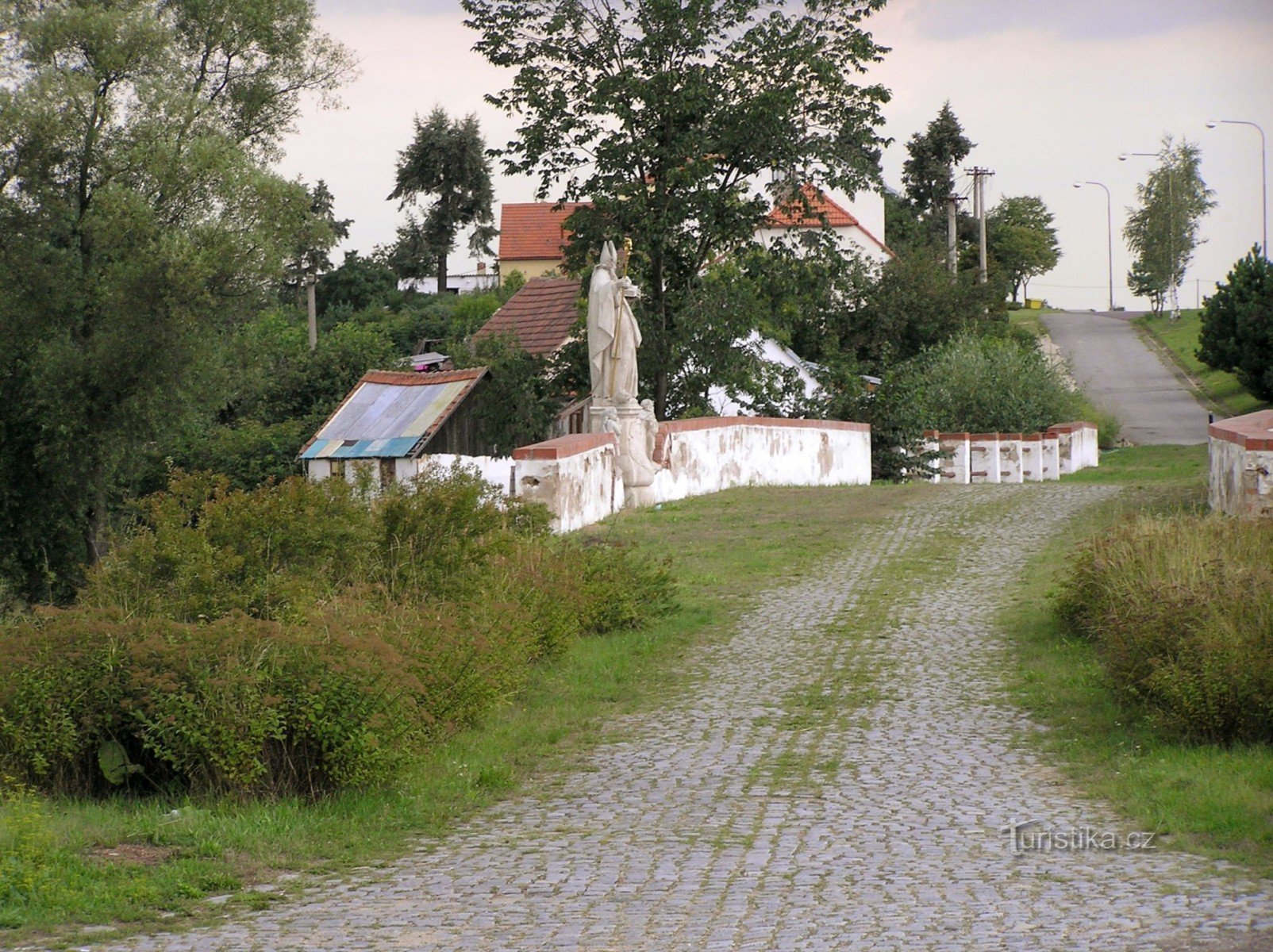o secțiune bine conservată a vechiului drum imperial asfaltat cu un pod (o statuie a Sfântului Nicolae pe el)