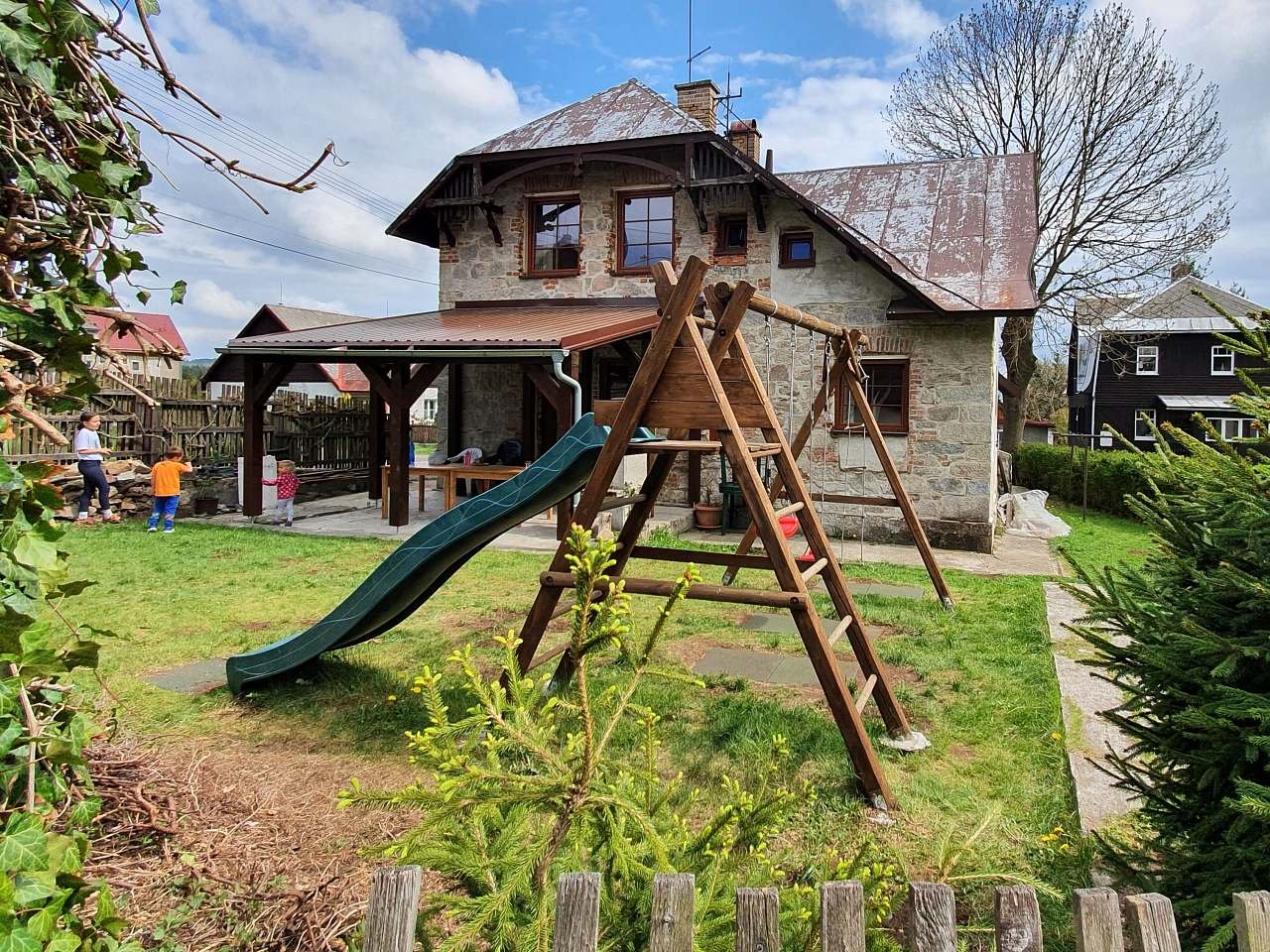 屋根付きのテラスと遊び場のある庭園