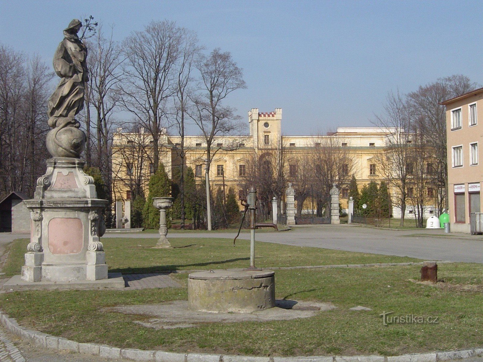 a castle with a fountain on a small square