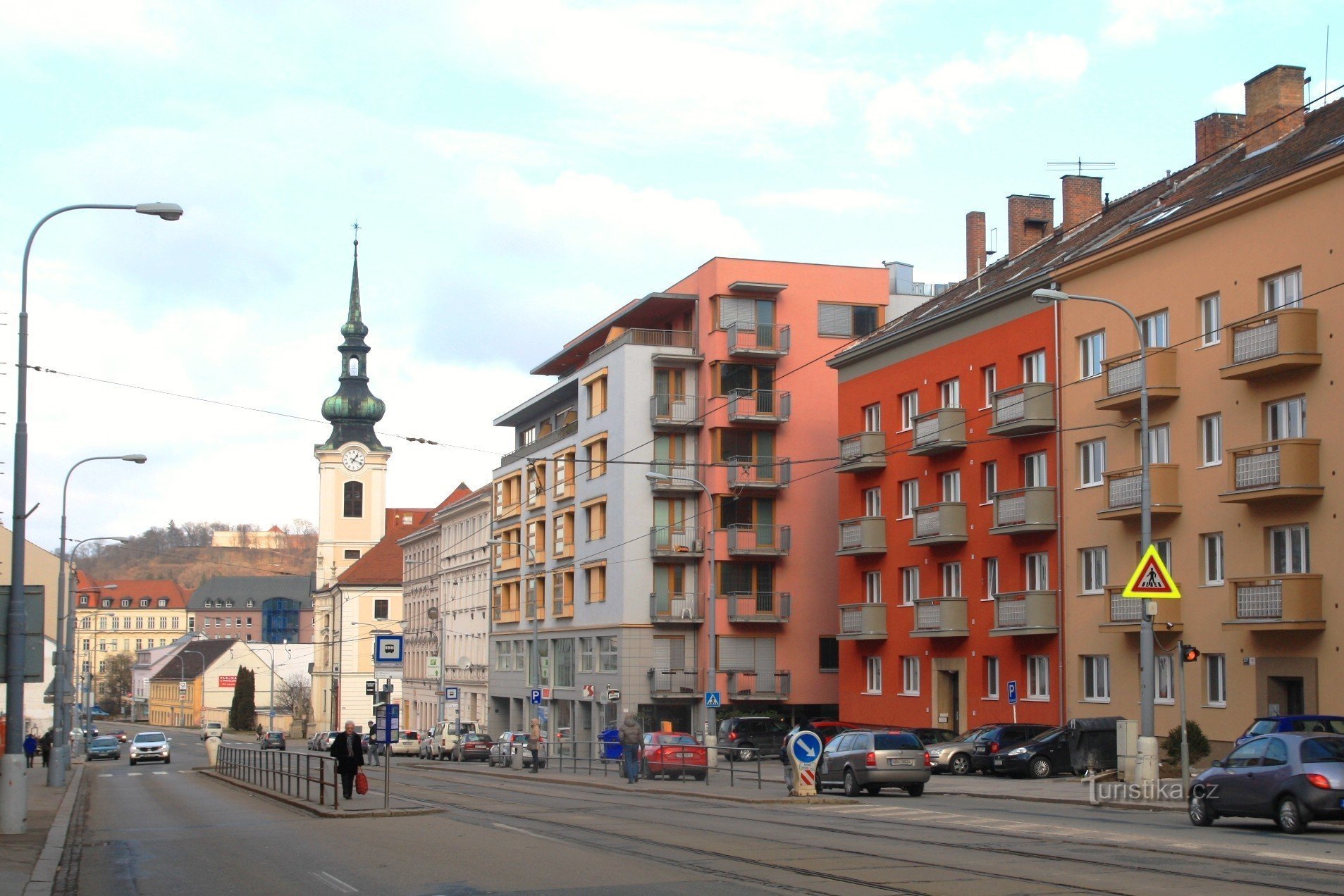 De barmhärtiga bröderna stannar för kollektivtrafiken på gatan Vídeňská, i bakgrunden tornet på kyrkan St. Leopold