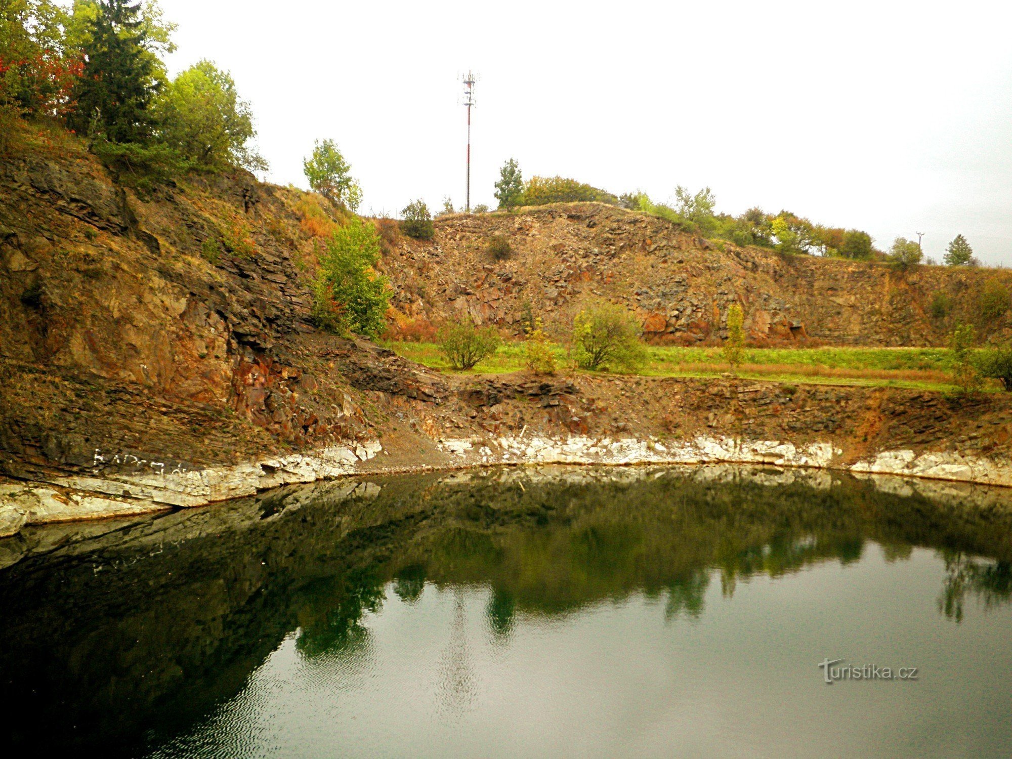 Flooded quarry, Heliš rock above