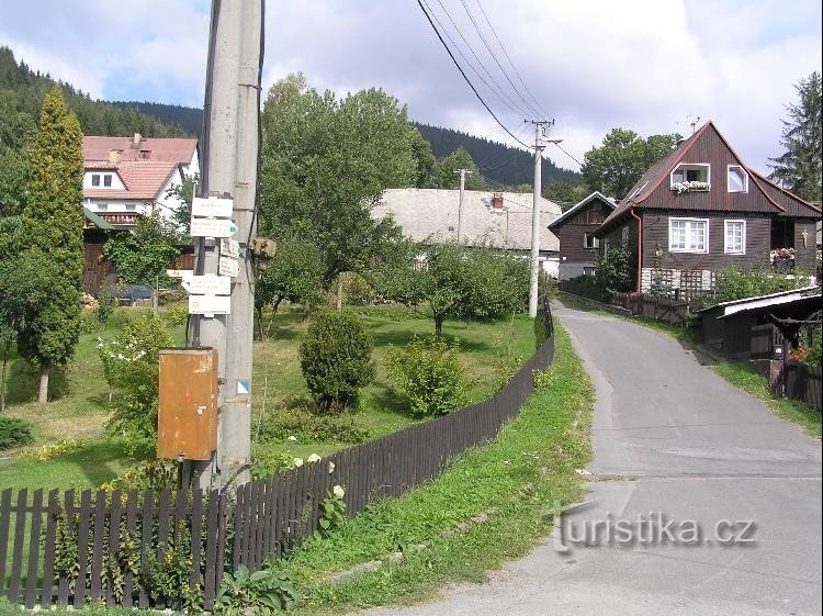 Železná: Blick auf das Dorf, Wegweiser im Vordergrund