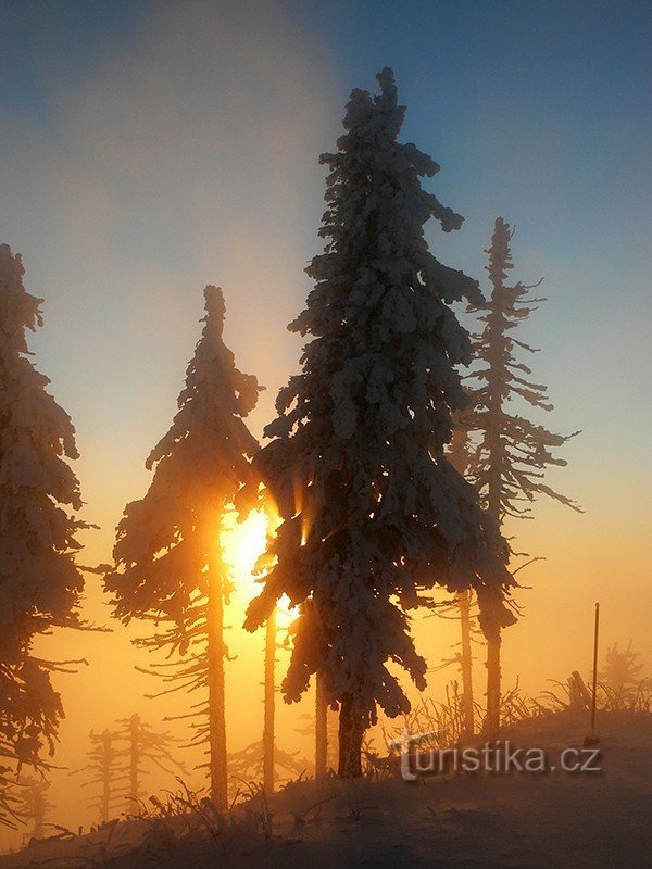 Winterzonsondergang op Lysá, versterkt door een sluier van mist