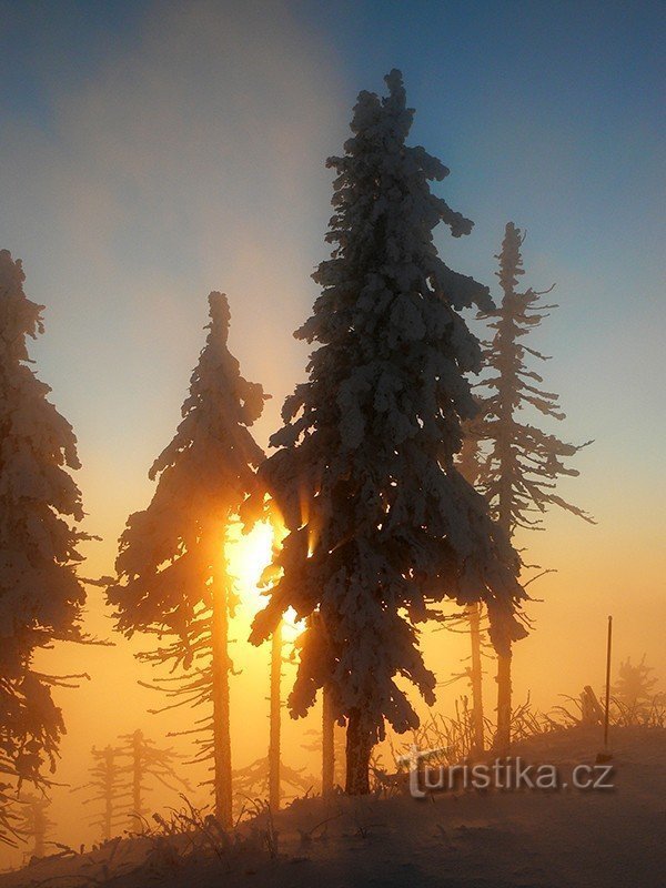 Pôr do sol de inverno em Lysá, realçado por um véu de neblina