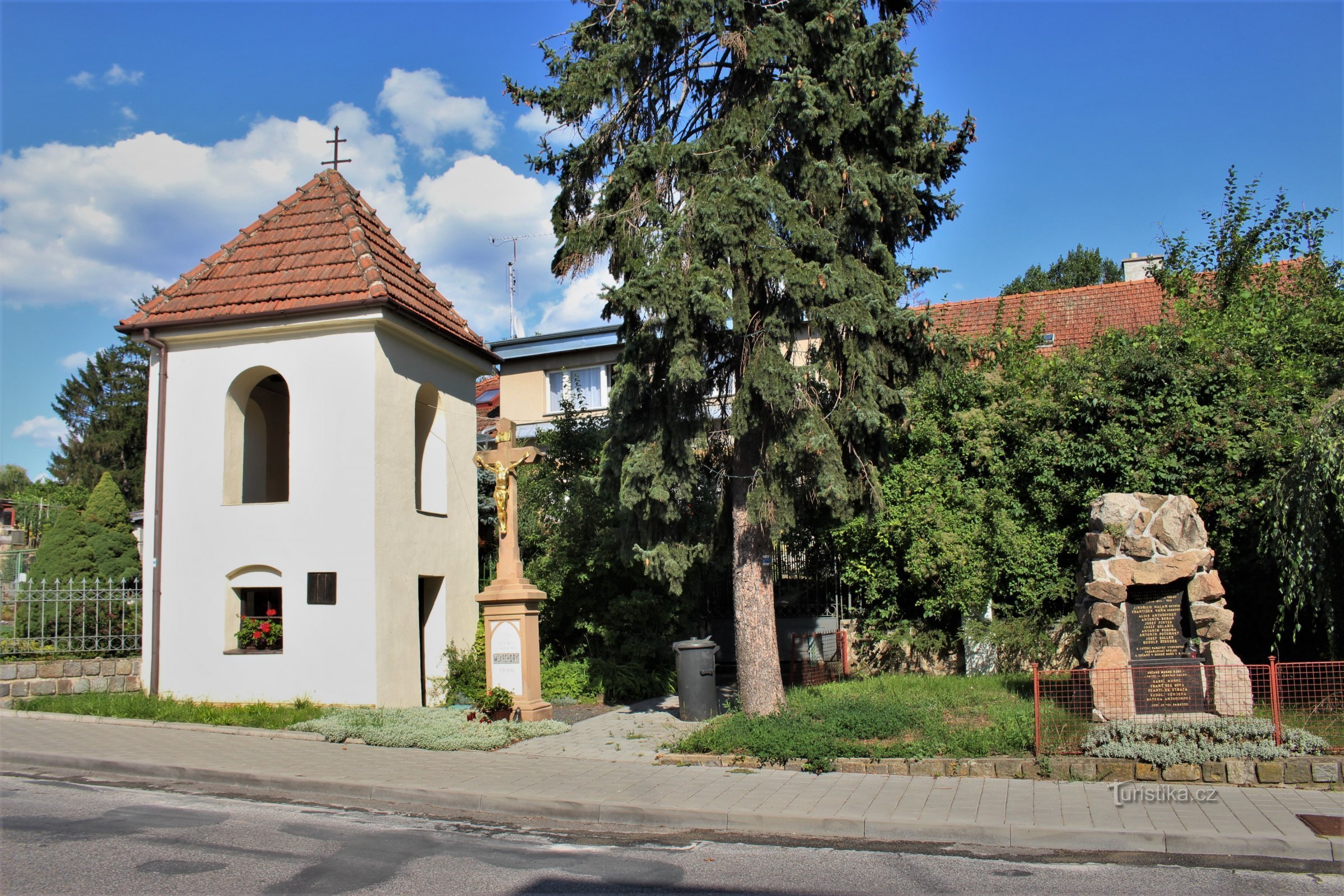 A bell tower with a monument to the fallen in the central part of the village