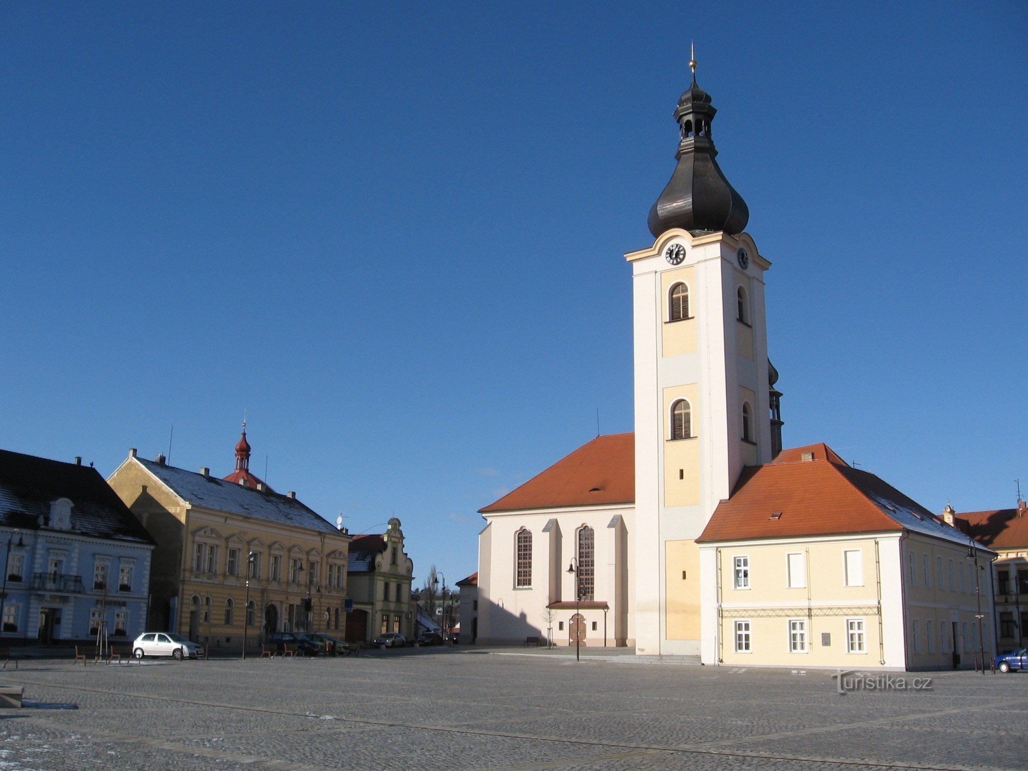 GLOCKE, ALTE SCHULE UND KIRCHE AUF DEM PLATZ IN DOBŘANE